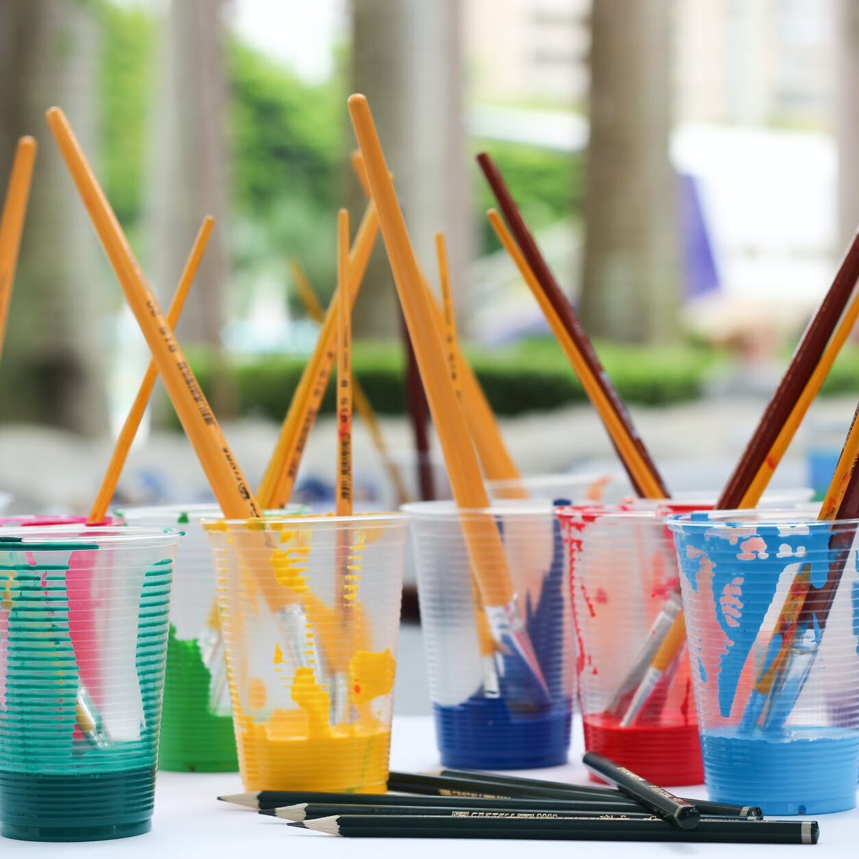 paint brushes inside clear plastic cups